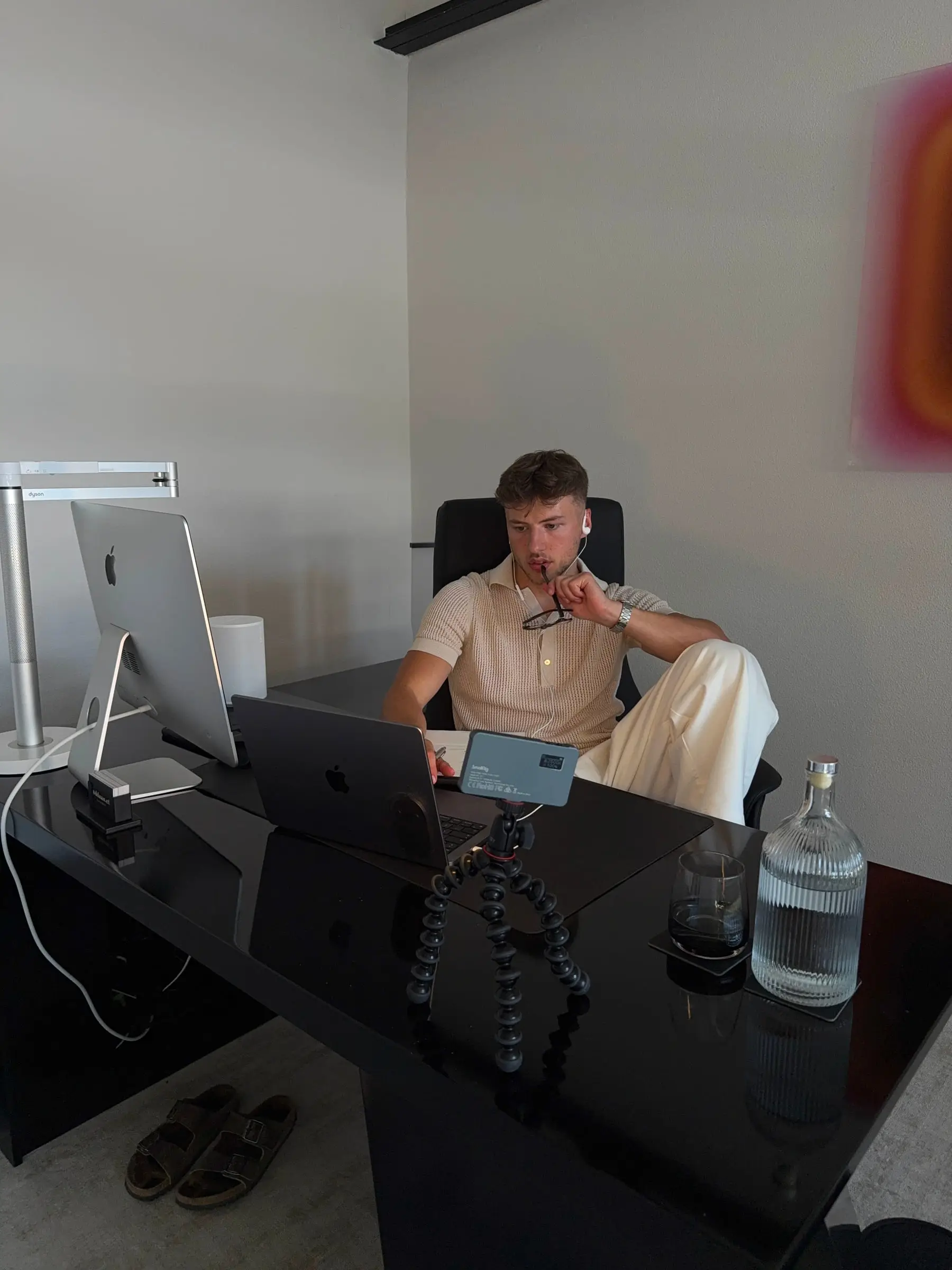 Daan at his desk, his phone on a tripod in front of him.